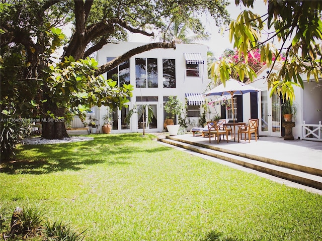 back of house with french doors, a yard, and a patio