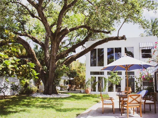 rear view of property featuring a patio and a lawn