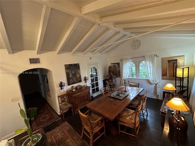 dining space with dark wood-type flooring and vaulted ceiling with beams