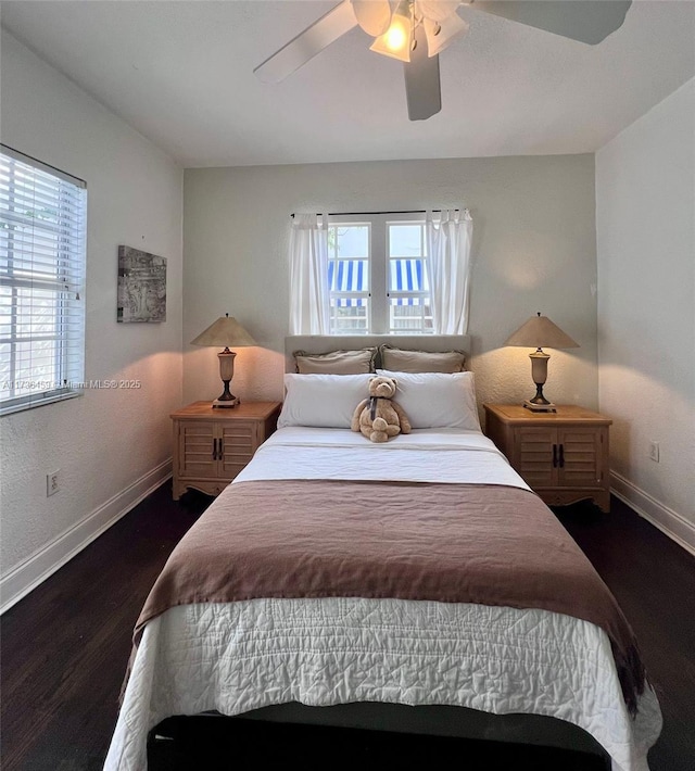 bedroom with multiple windows, ceiling fan, and dark hardwood / wood-style flooring