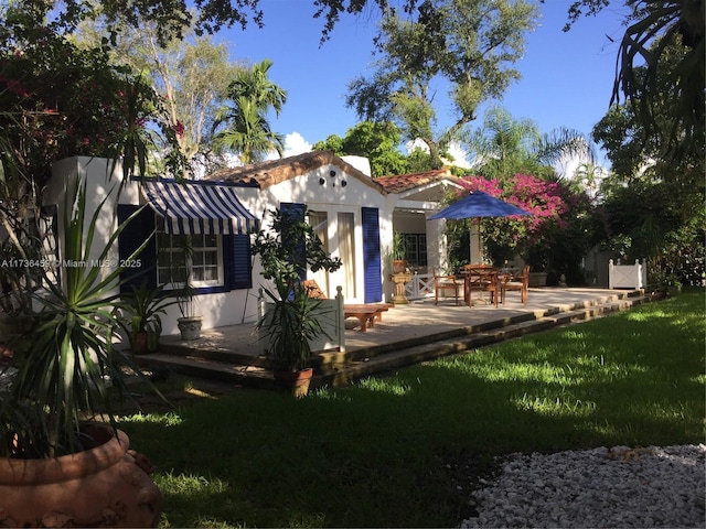 rear view of house with an outdoor structure and a yard