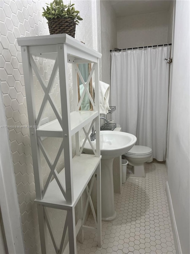 bathroom featuring a shower with shower curtain, tile patterned floors, and toilet