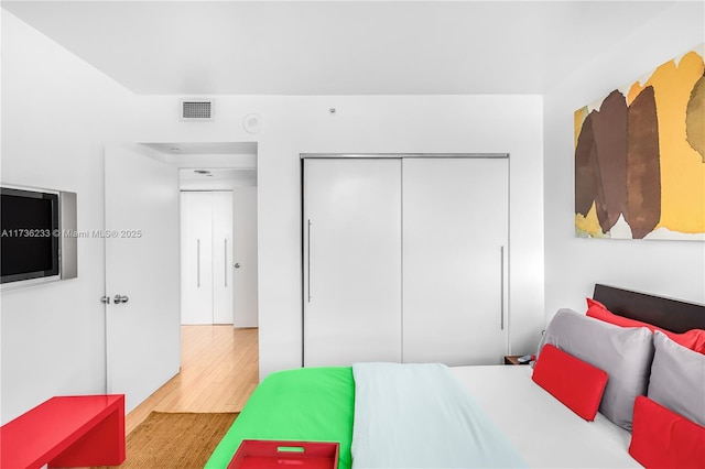 bedroom featuring wood-type flooring and a closet