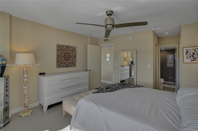 bedroom with ensuite bathroom, light tile patterned floors, and ceiling fan