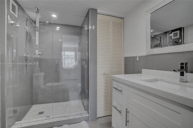 bathroom with a shower with door and vanity