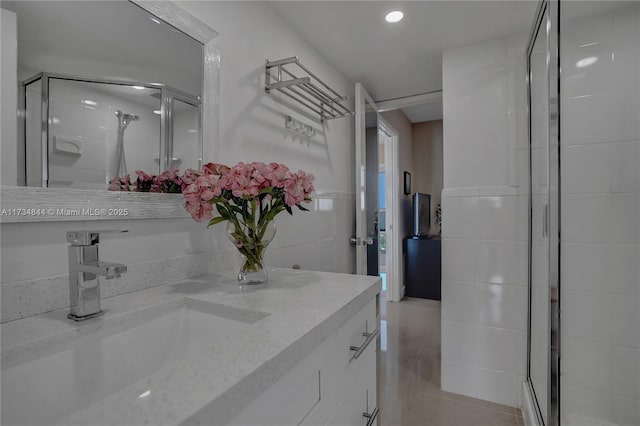 bathroom with vanity and a shower with shower door