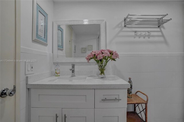 bathroom with vanity and tile walls