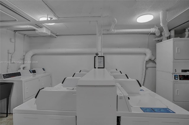 clothes washing area with stacked washer / drying machine, separate washer and dryer, and a textured ceiling