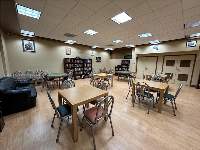 dining area featuring a paneled ceiling and light wood-type flooring