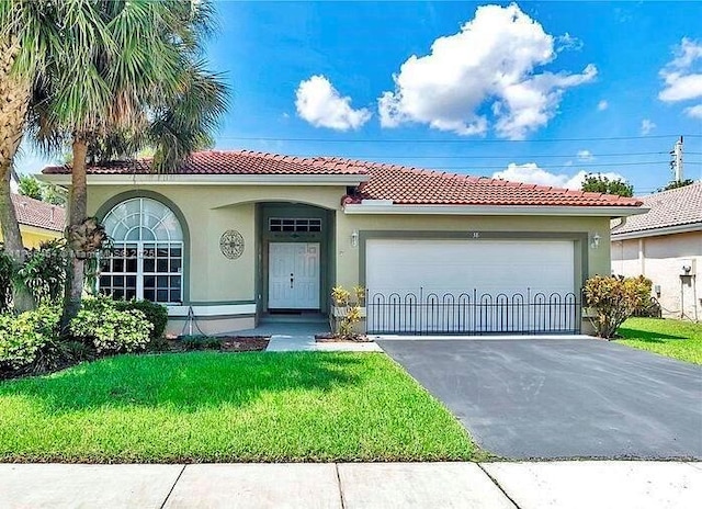 view of front of home with a garage and a front lawn