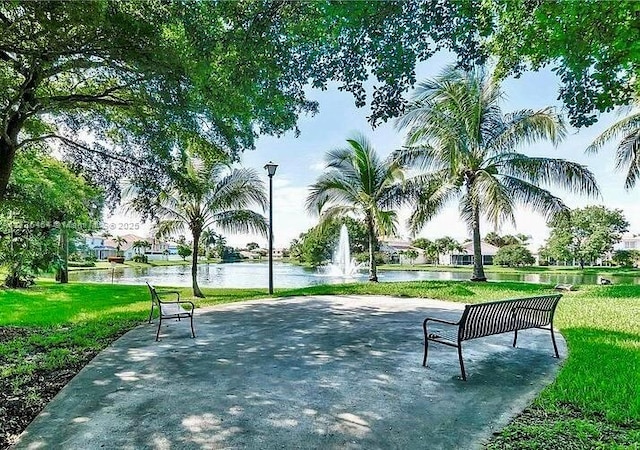 surrounding community featuring a water view and a yard