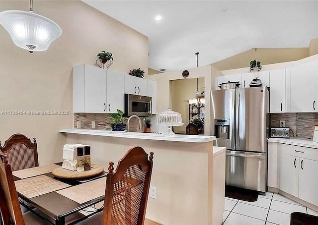 kitchen featuring appliances with stainless steel finishes, decorative light fixtures, and white cabinets