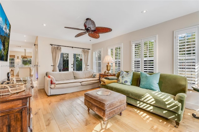 living room with ceiling fan, a healthy amount of sunlight, light hardwood / wood-style floors, and french doors