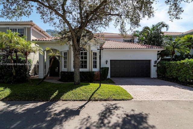 mediterranean / spanish-style home with a garage and a front lawn