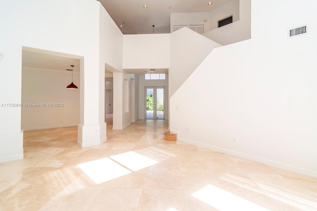 empty room with a towering ceiling and french doors