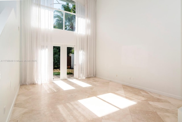 unfurnished room featuring a towering ceiling