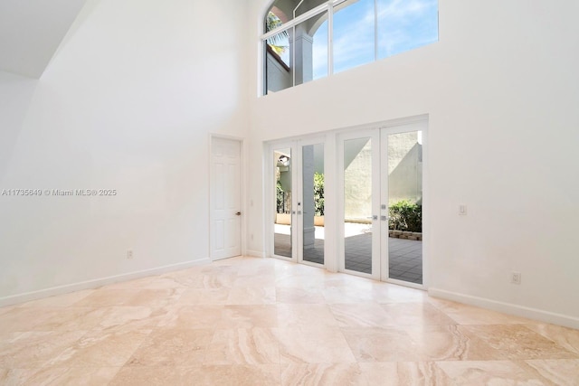 empty room featuring a high ceiling and french doors