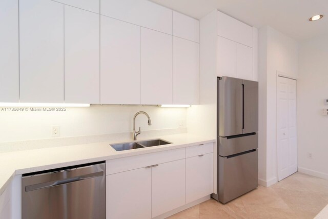 kitchen featuring white cabinetry, stainless steel appliances, and sink