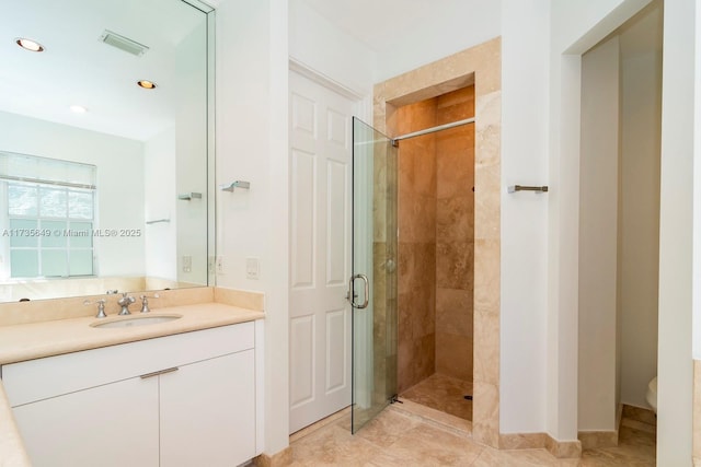 bathroom featuring vanity, tile patterned floors, a shower with door, and toilet