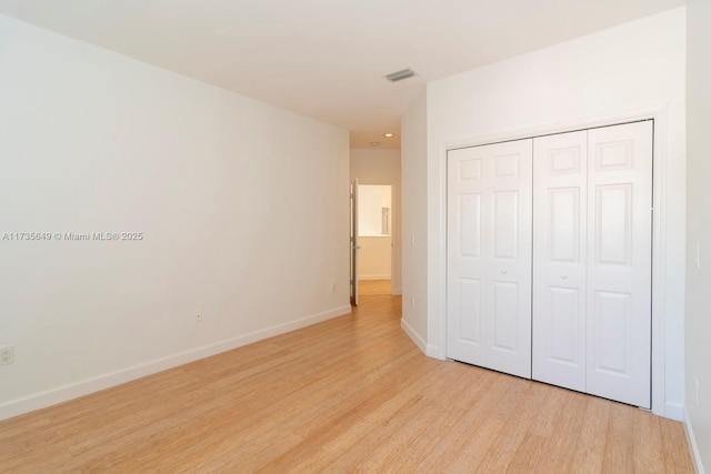 unfurnished bedroom featuring light hardwood / wood-style floors and a closet