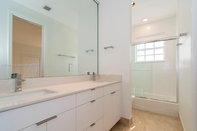 full bathroom featuring tile patterned flooring, vanity, combined bath / shower with glass door, and toilet