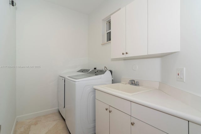 clothes washing area featuring cabinets, washer and dryer, and sink