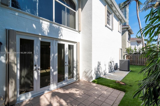 back of house with a yard, central AC, a patio area, and french doors