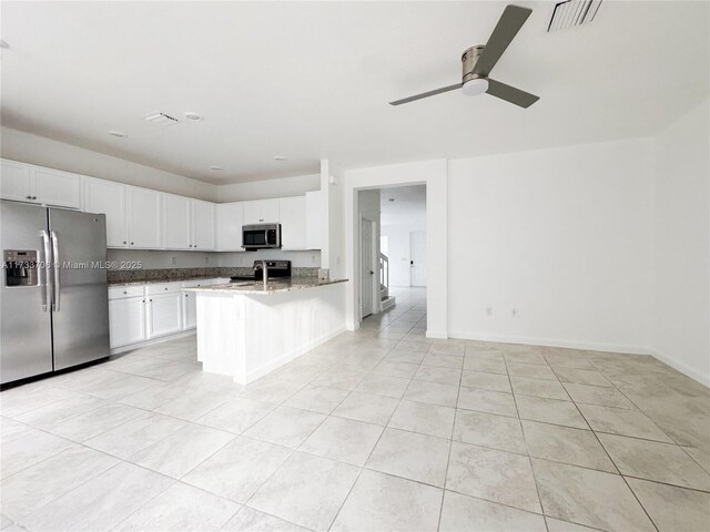 kitchen with white cabinetry, light tile patterned floors, dark stone countertops, appliances with stainless steel finishes, and ceiling fan