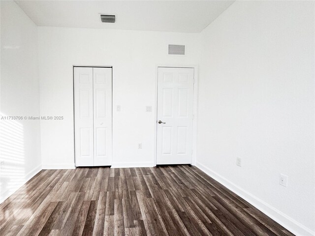 unfurnished room with dark wood-type flooring