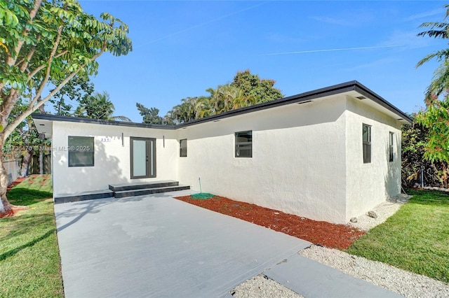 single story home with a front yard and a patio area