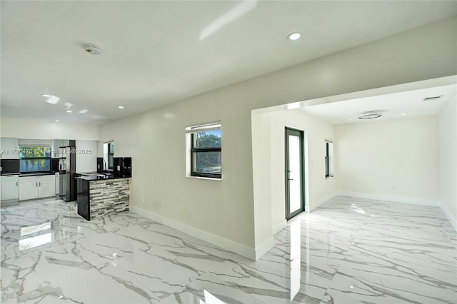 interior space with stainless steel fridge and white cabinets