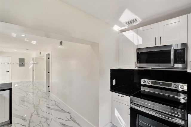 kitchen featuring stainless steel appliances and white cabinetry