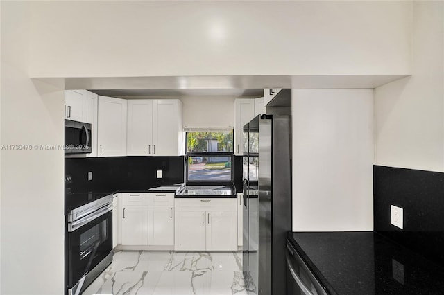 kitchen featuring tasteful backsplash, appliances with stainless steel finishes, and white cabinets