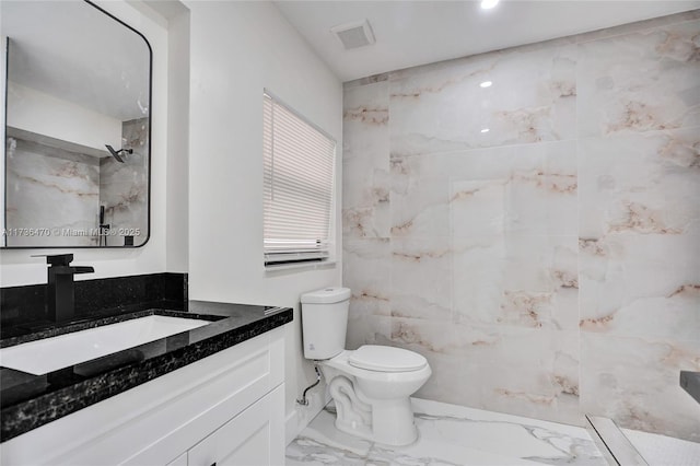 bathroom with vanity, toilet, and a shower