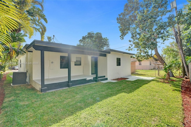 rear view of property featuring a yard and a patio