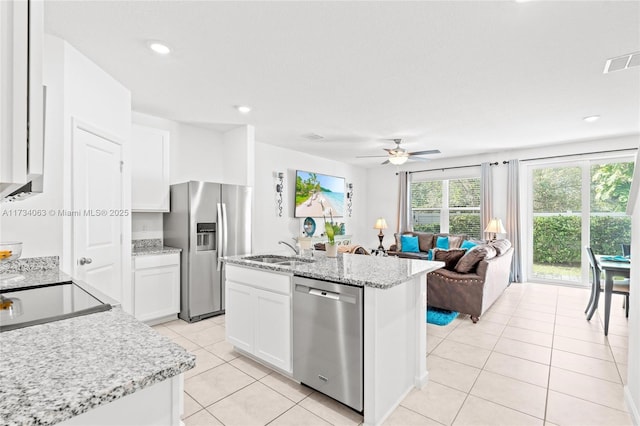 kitchen featuring sink, light stone counters, appliances with stainless steel finishes, a kitchen island with sink, and white cabinets