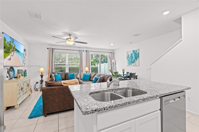 kitchen with white cabinetry, an island with sink, sink, stainless steel dishwasher, and light stone counters