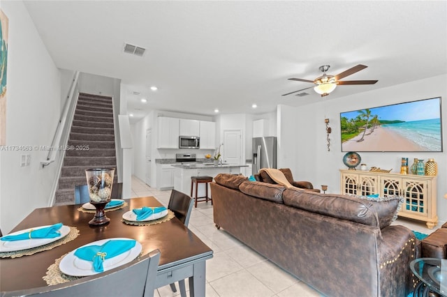 living room featuring light tile patterned floors, sink, and ceiling fan