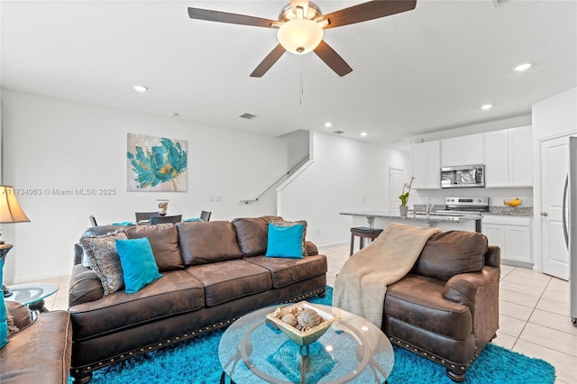 tiled living room with sink, a textured ceiling, and ceiling fan