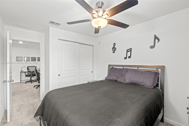 carpeted bedroom featuring a textured ceiling, a closet, and ceiling fan