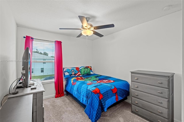 carpeted bedroom featuring ceiling fan and a textured ceiling