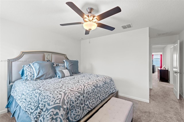 carpeted bedroom featuring ceiling fan and a textured ceiling