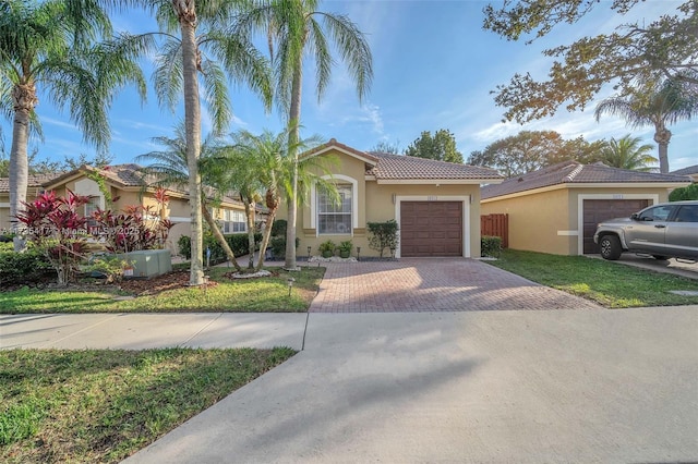 mediterranean / spanish-style home featuring a garage and a front yard