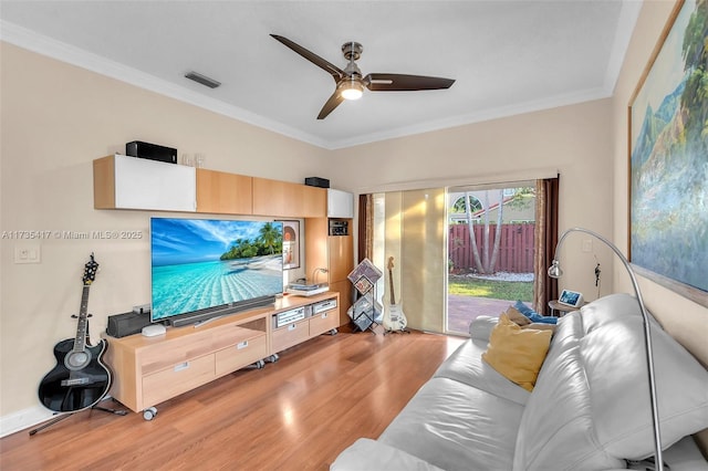 living room with hardwood / wood-style flooring, ceiling fan, and crown molding