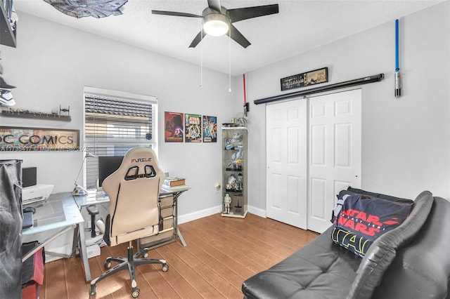 home office with ceiling fan, wood-type flooring, and a textured ceiling