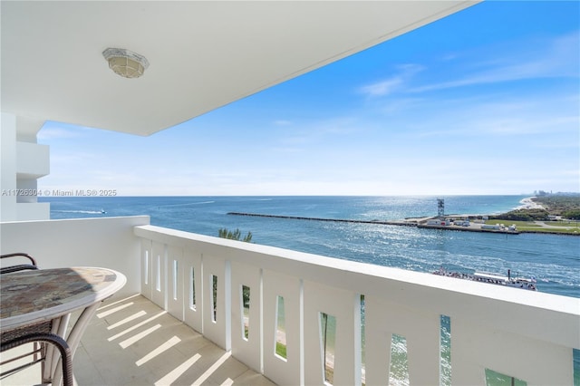 balcony featuring a water view and a beach view