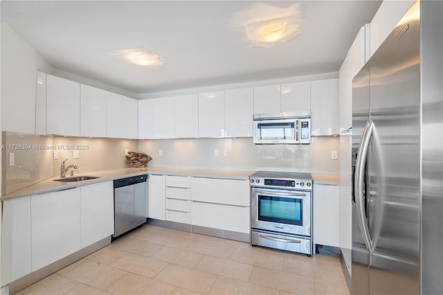 kitchen featuring stainless steel appliances, white cabinetry, sink, and decorative backsplash