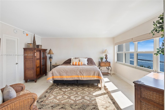 bedroom featuring ornamental molding and a water view