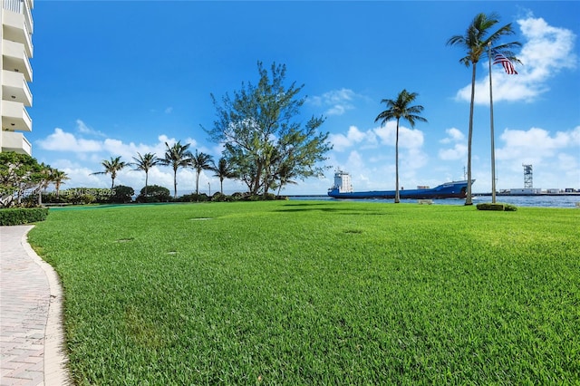 surrounding community featuring a water view and a lawn