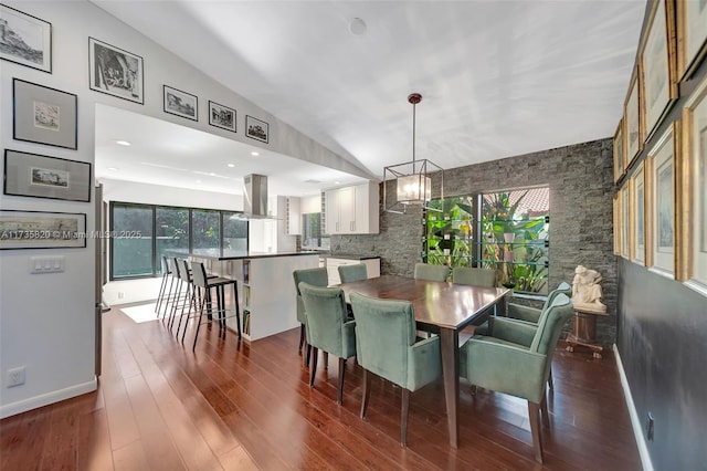 dining room with an inviting chandelier, lofted ceiling, dark hardwood / wood-style floors, and a wealth of natural light